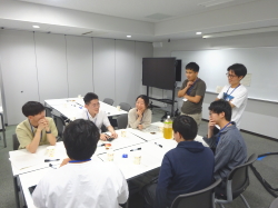 テーブルを囲んで話す8人
