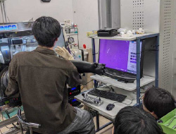 後ろ向きに座る茶色い服の男性