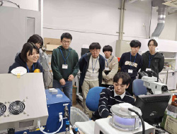 座って説明する男性を囲んで話を聞く人たち