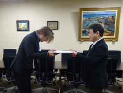 修了証を受け取る黒い服の男性