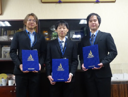 青い賞状入れを持って立つ3人の男性