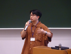 茶色いシャツのマイクを持つ男性