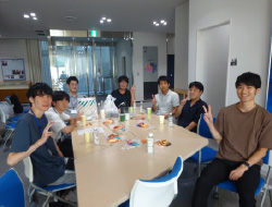 ピースサインをしてテーブルを囲む大学生たち